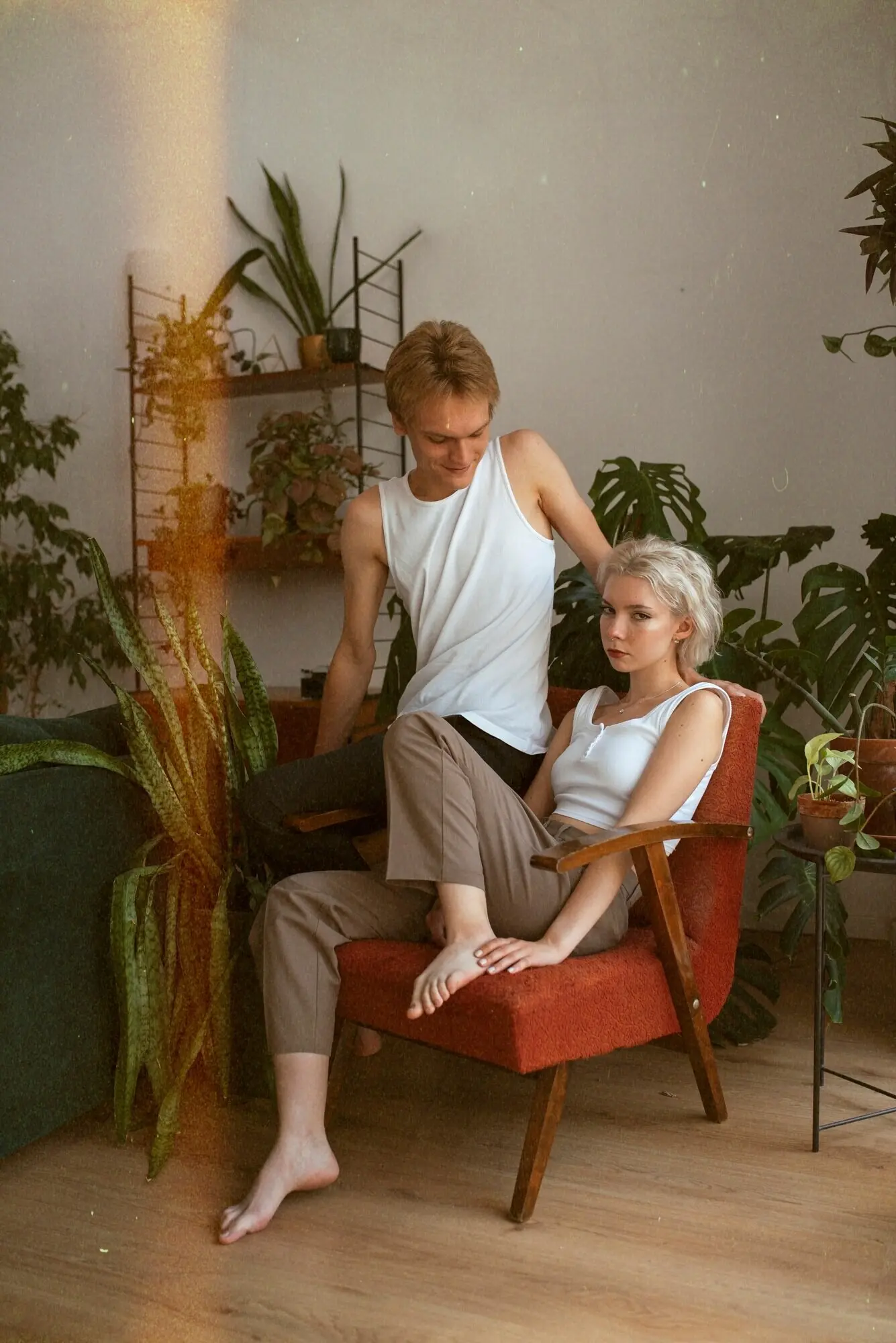 Ganzkörperaufnahme eines Paares, das in Innenräumen posiert.